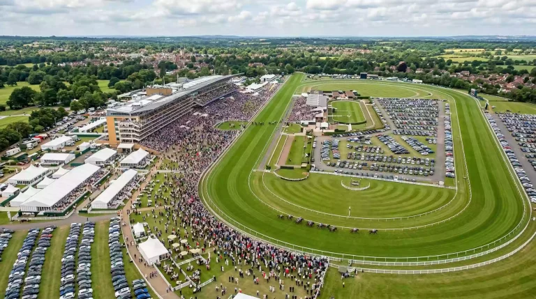 Aerial view of a busy British racecourse showing the grandstand crowds car parks and surrounding facilities